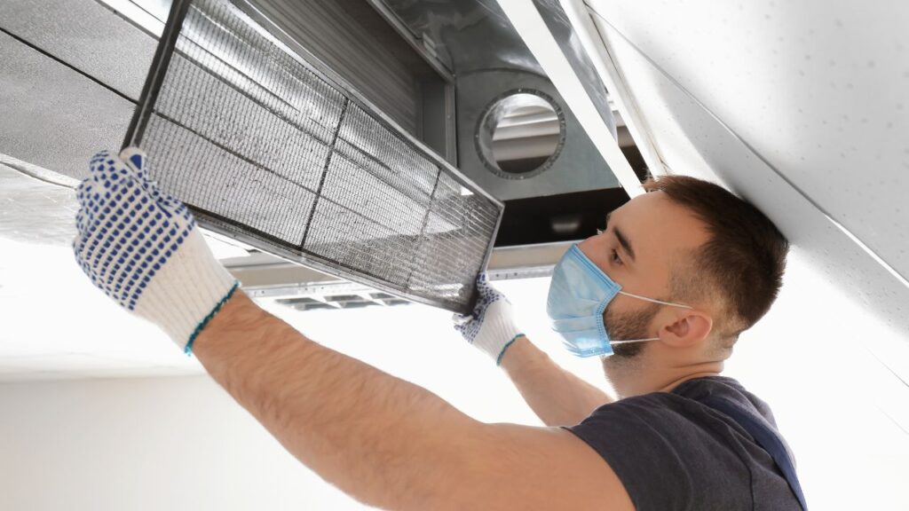 a professional using special equipment to clean the expansive web of air ducts in a home
