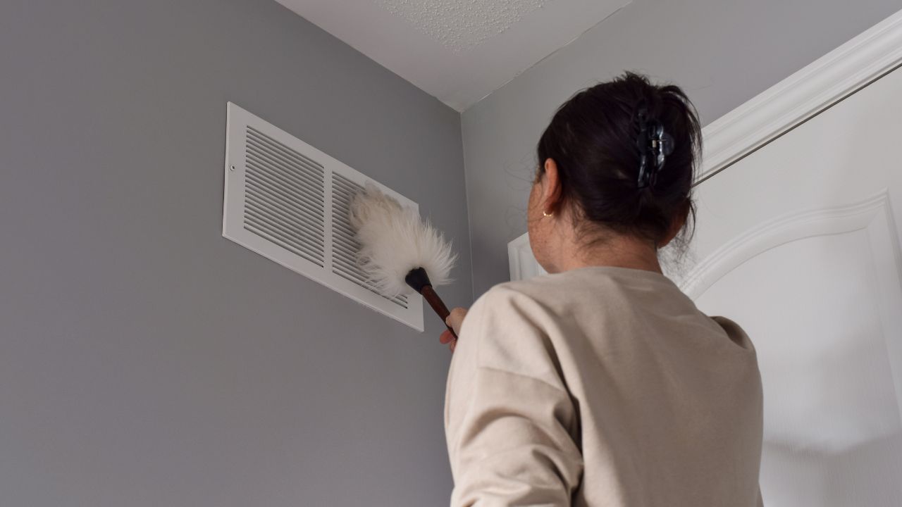 homeowners cleaning air duct vent