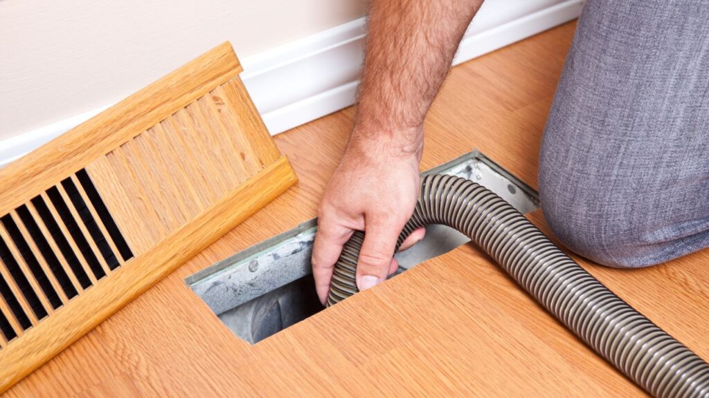 contractor cleaning air duct vigorously