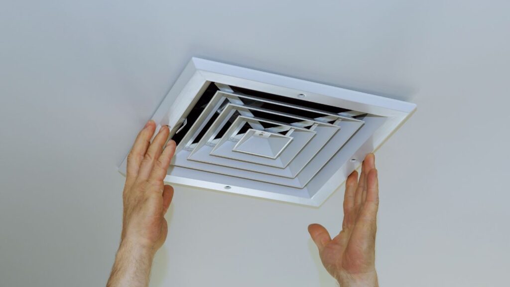 close up man hand installing vent- over from ceiling