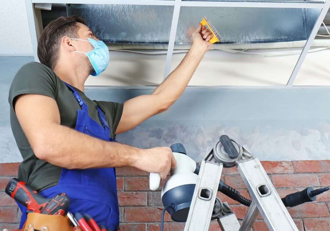 a guy cleaning an air duct